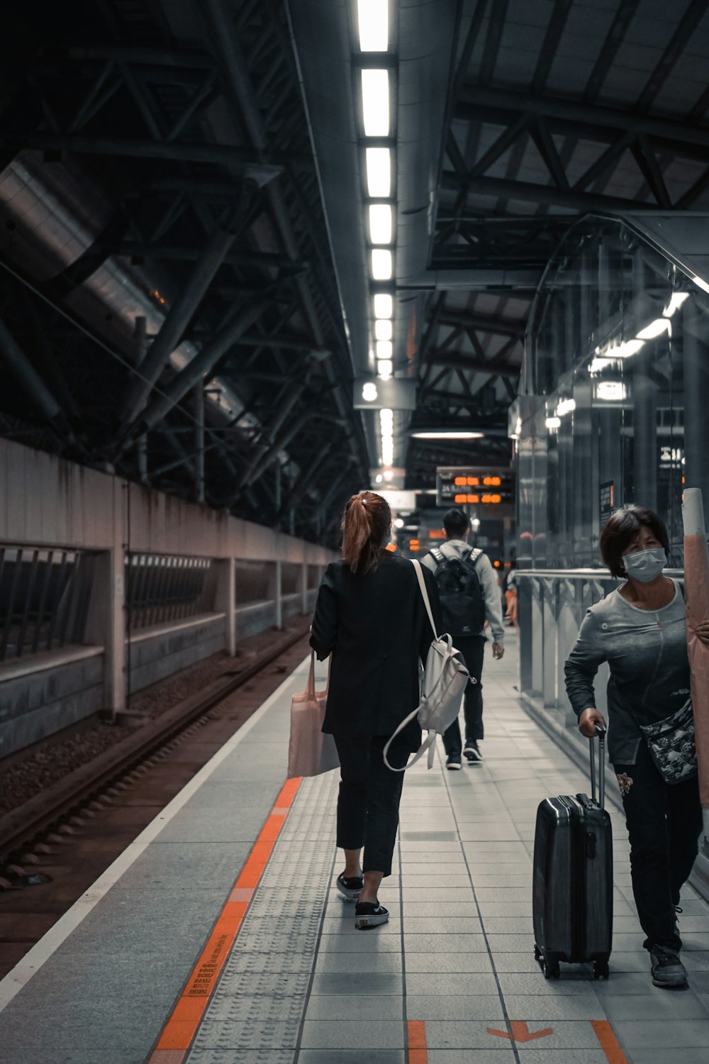 woman in black jacket walking on train station
