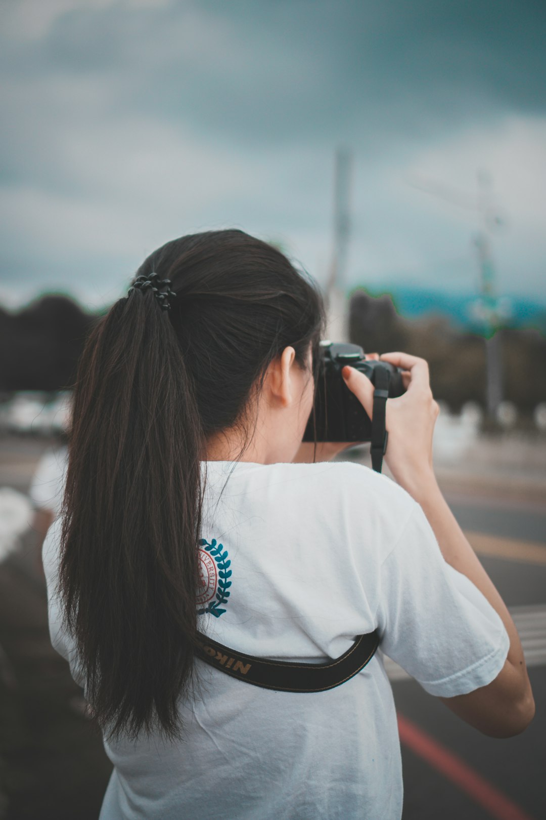 woman in white shirt using black dslr camera during daytime