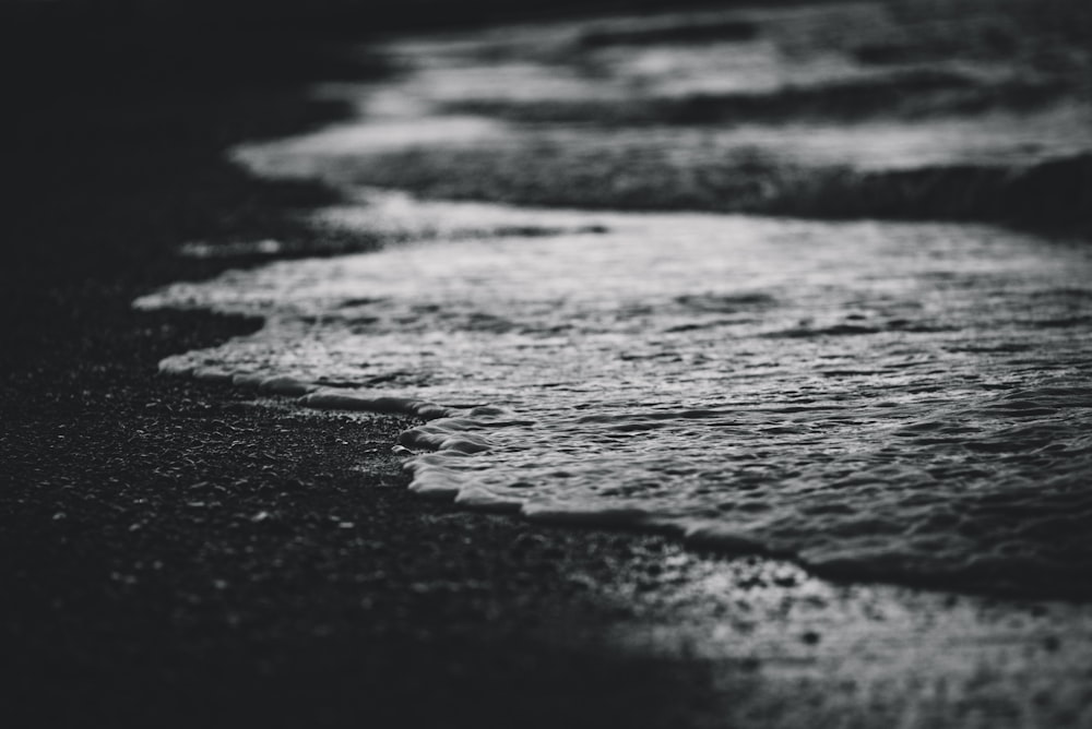 Una foto en blanco y negro de las olas en la playa
