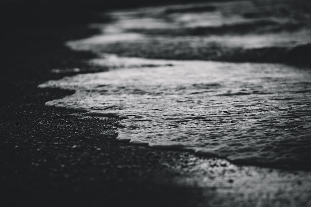 a black and white photo of waves on the beach