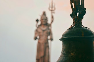 black bell with three human statues