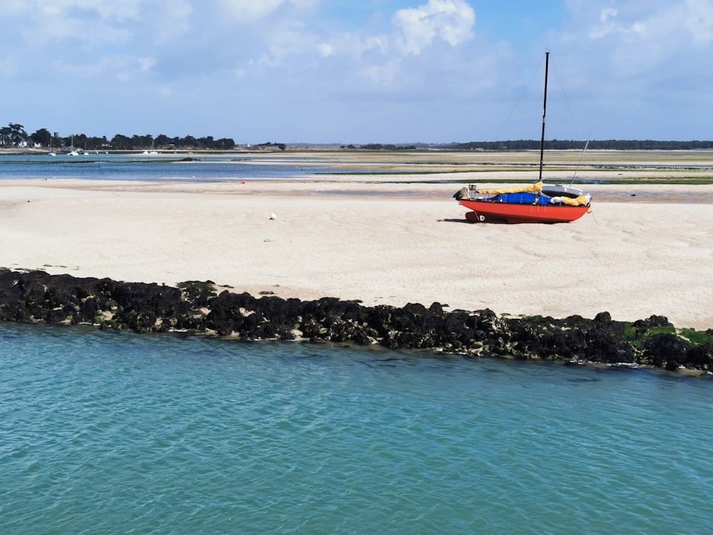 orange and white boat on sea shore during daytime