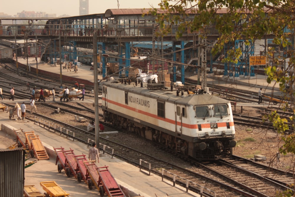 red and white train on rail tracks during daytime