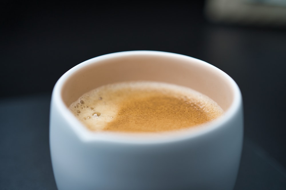 white ceramic mug with brown liquid