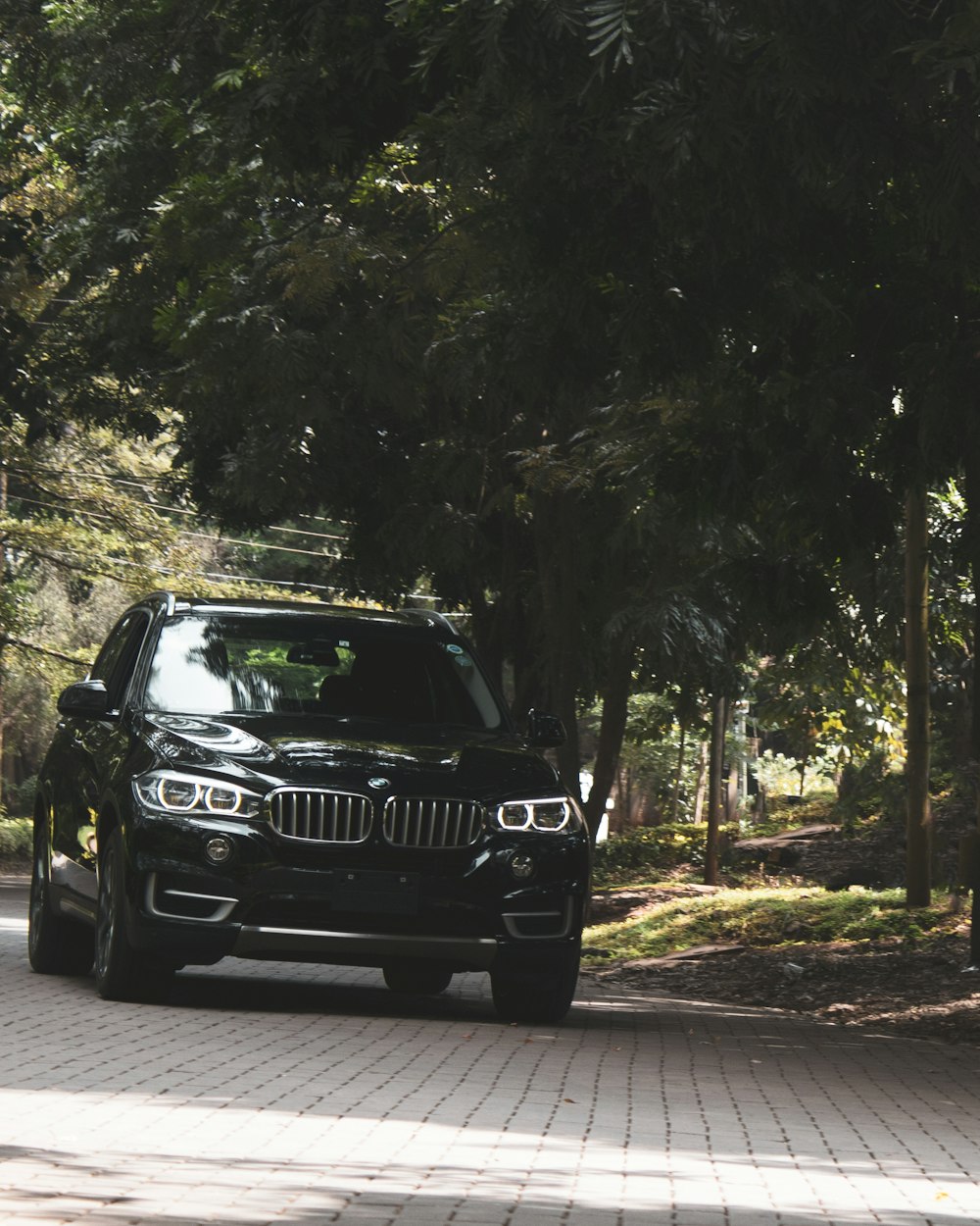 black mercedes benz g class suv parked on gray concrete road during daytime