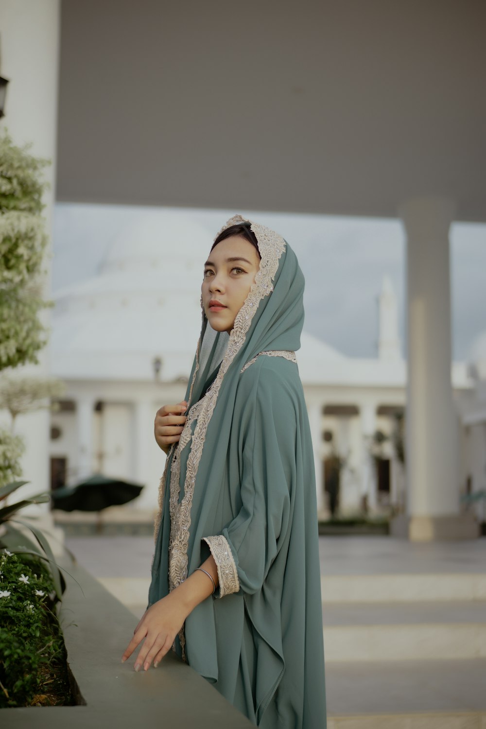 woman in blue hijab standing near green plant during daytime