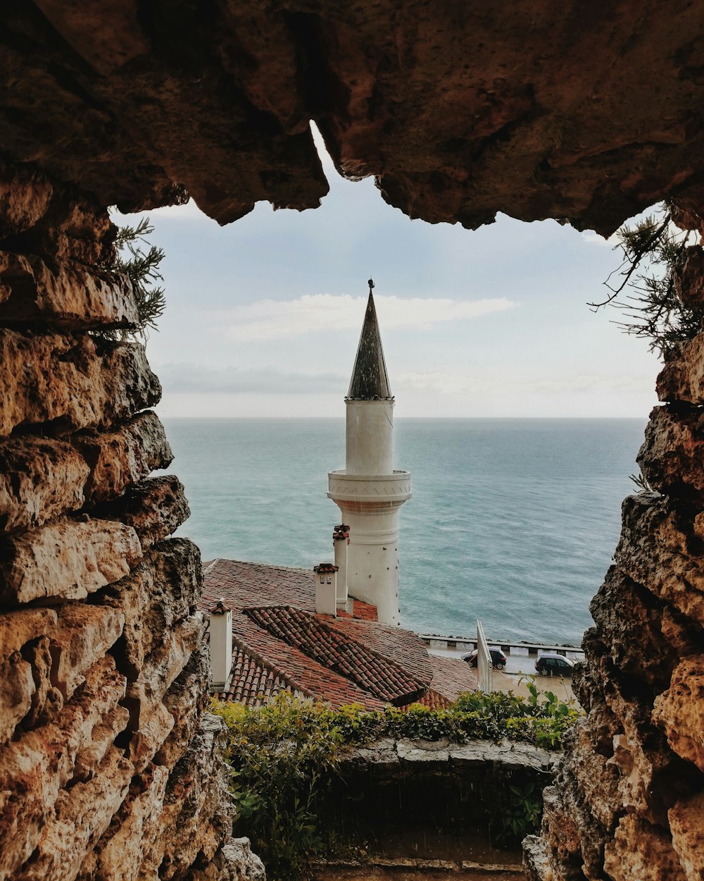 Faro de hormigón blanco y marrón cerca de la formación rocosa marrón durante el día