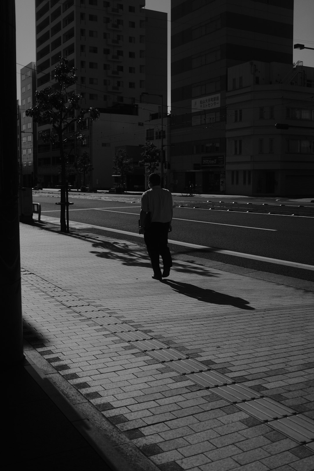 man in black jacket walking on sidewalk during daytime