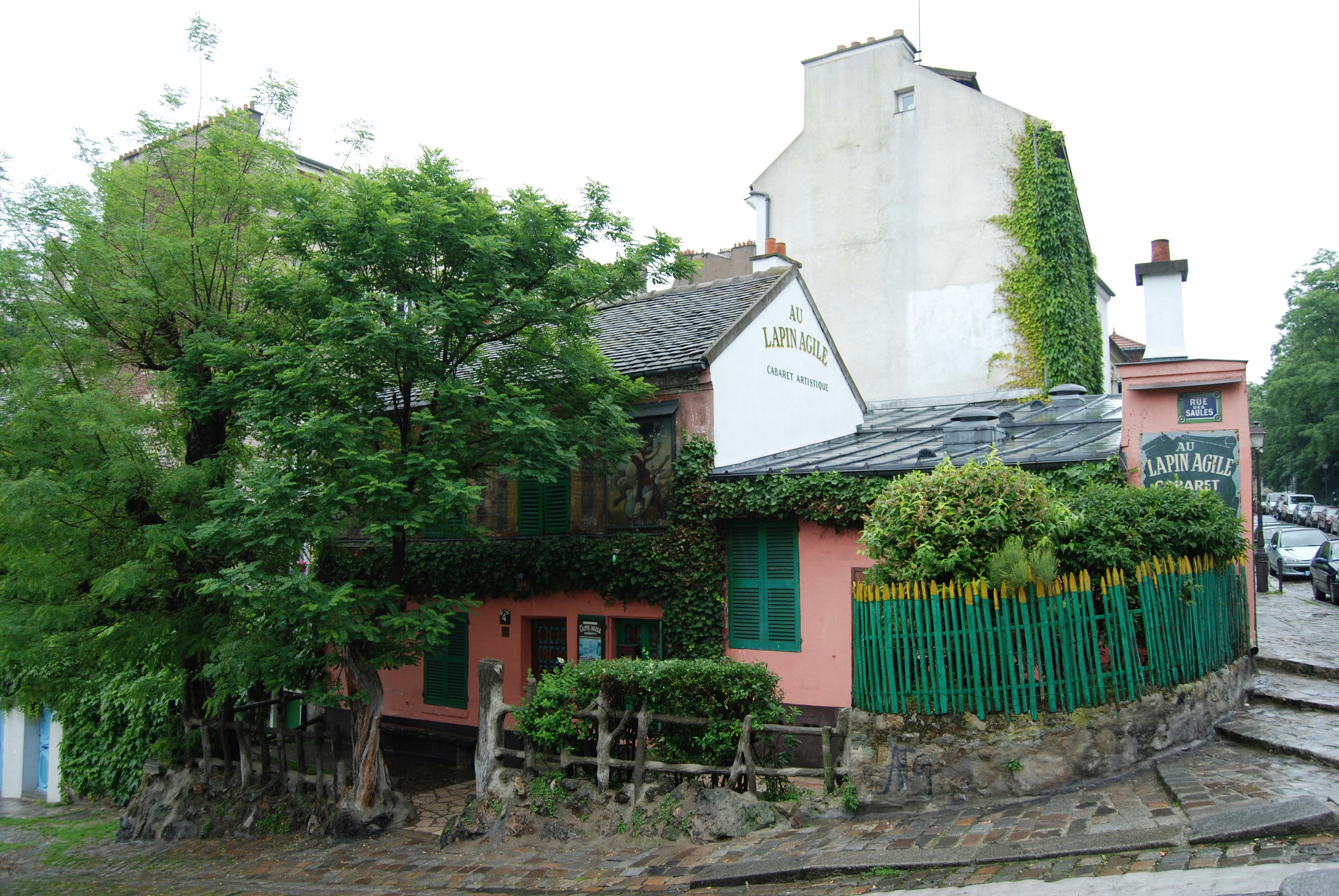 Green and brown concrete house near green trees during daytime