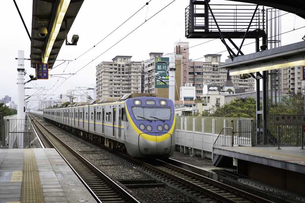 昼間の線路を走る青と白の列車