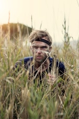 man in black jacket lying on green grass during daytime