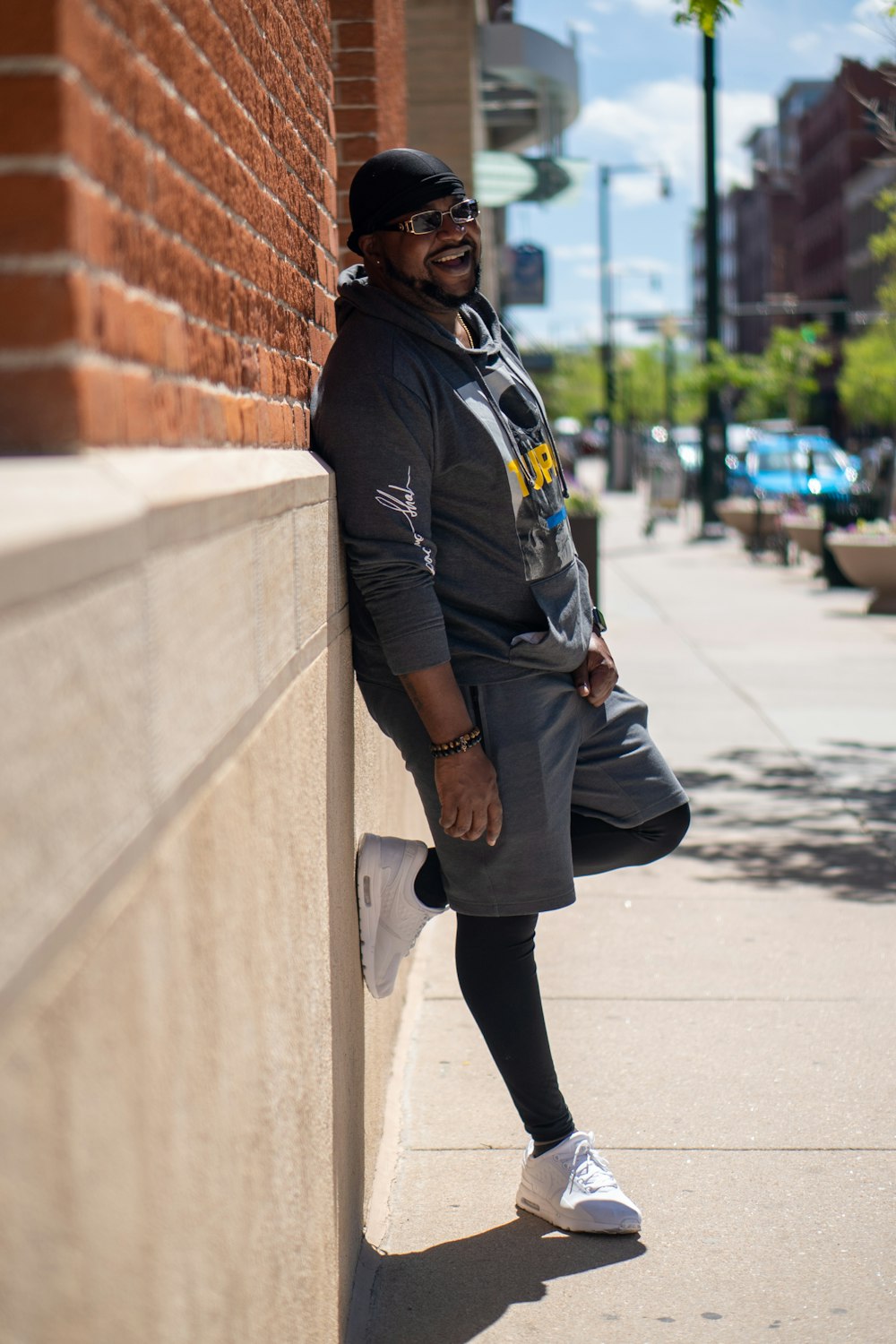 woman in black jacket and black pants standing on sidewalk during daytime