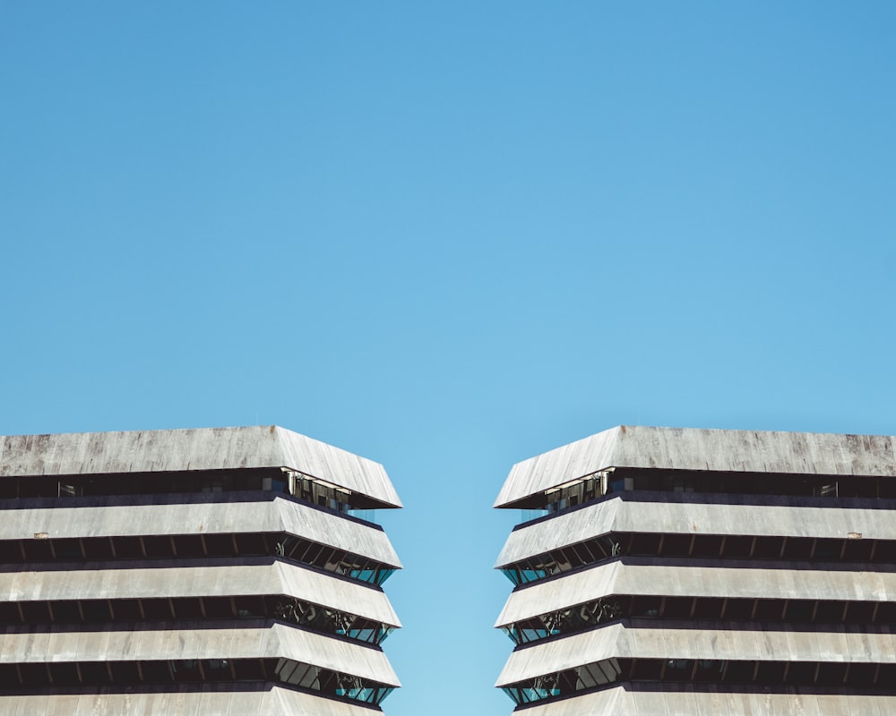 Weißes Betongebäude unter blauem Himmel tagsüber