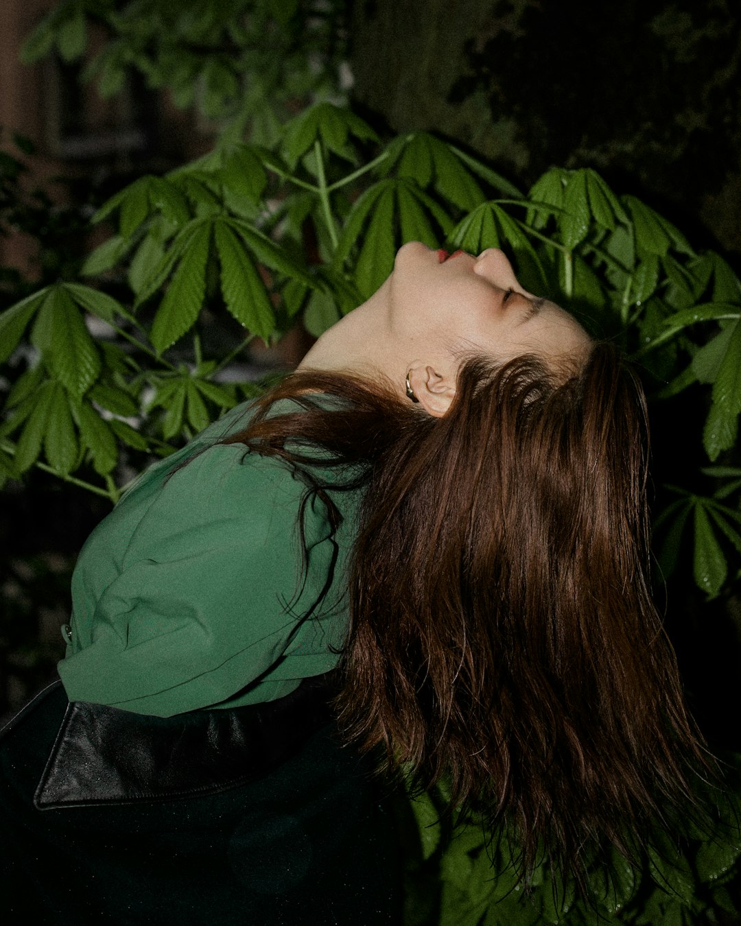 woman in green shirt covering her face with her hair