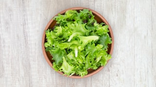 green vegetable on brown round plastic bowl
