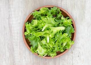 green vegetable on brown round plastic bowl