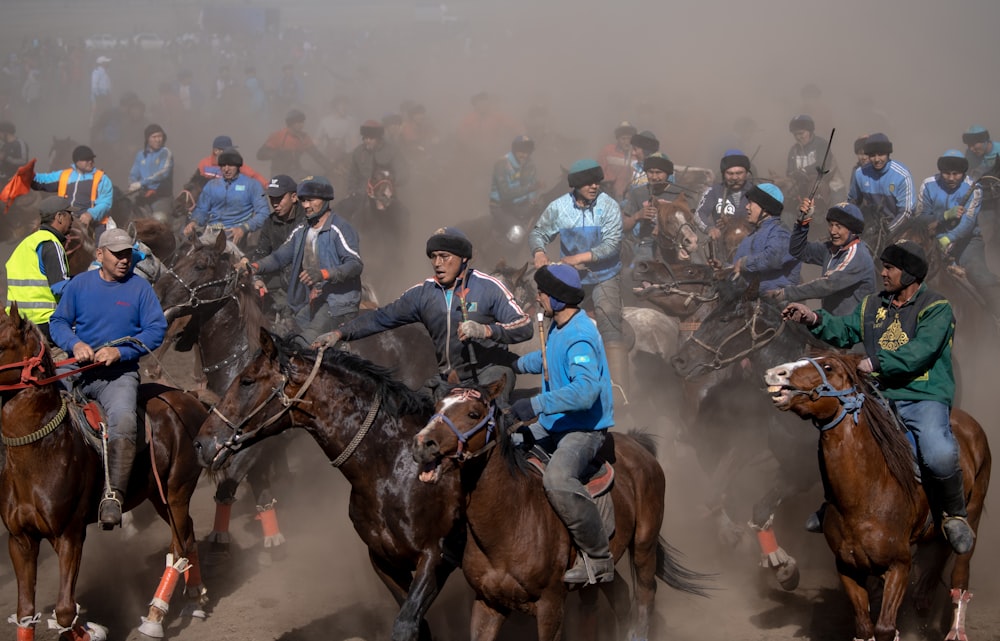 people riding horses on field during daytime