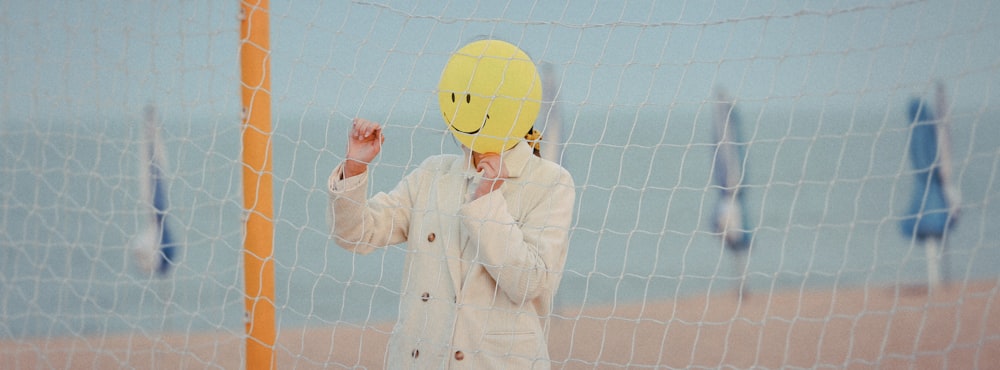 woman in white coat holding yellow balloon