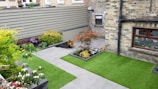A beautifully maintained backyard featuring concrete garden beds and a freshly painted fence.