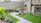 A vibrant backyard with fresh artificial turf and a smiling family enjoying the space.