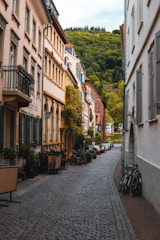 black bicycle parked on sidewalk in between of buildings during daytime