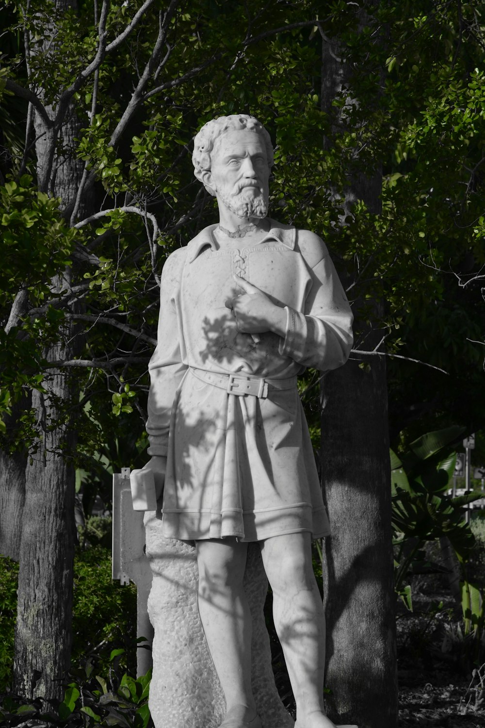 man statue near green trees
