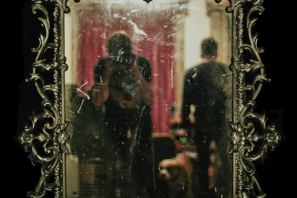 man in black jacket standing in front of mirror