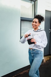 woman in white long sleeve shirt holding white ceramic mug