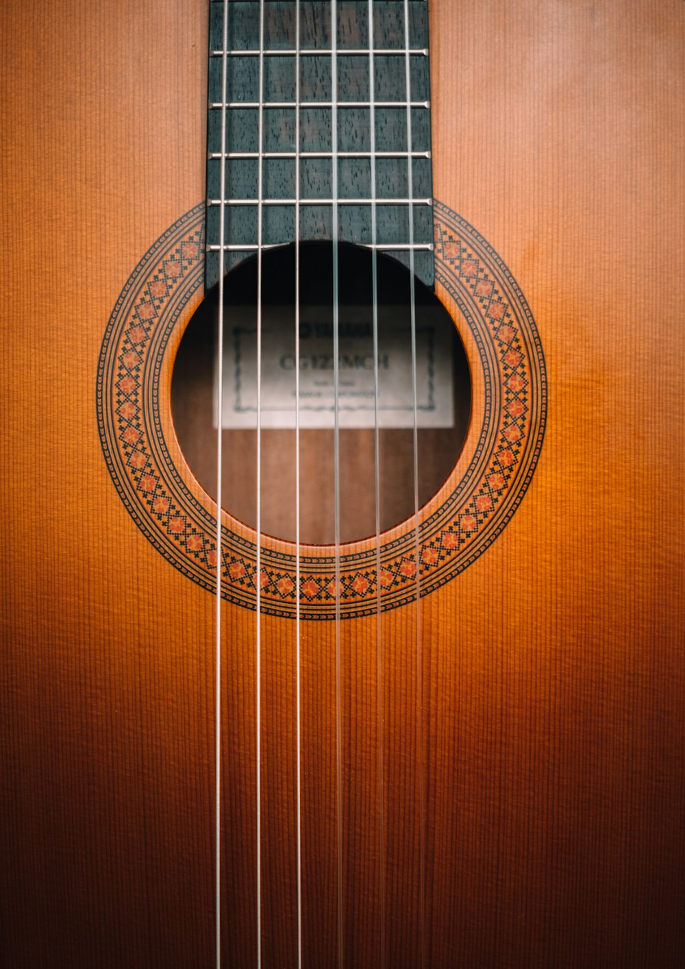 Guitarra acústica marrón sobre superficie de madera marrón