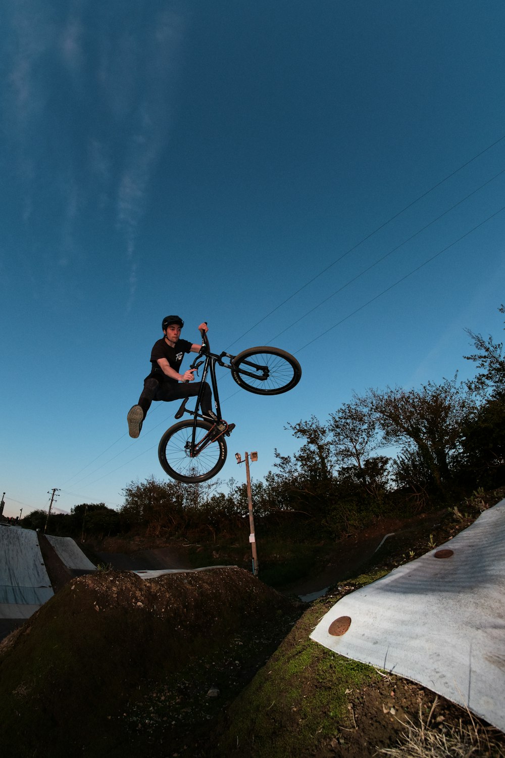 man in green shirt riding on black bmx bike during daytime