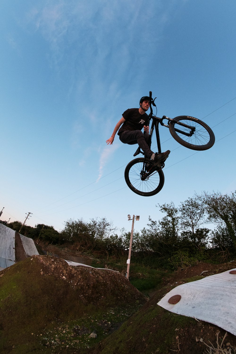 man in black t-shirt riding on black bmx bike