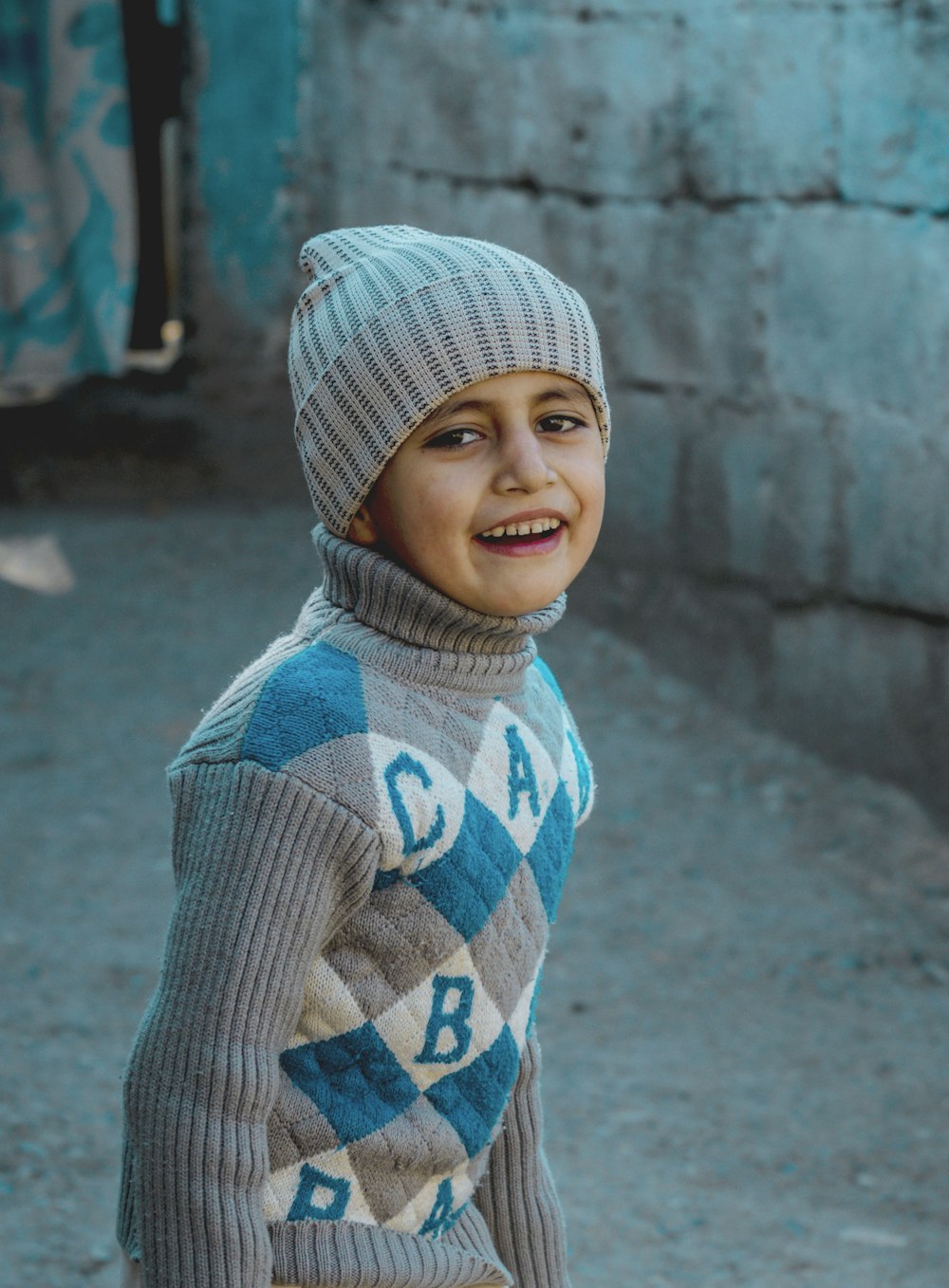 girl in gray and blue knit cap smiling