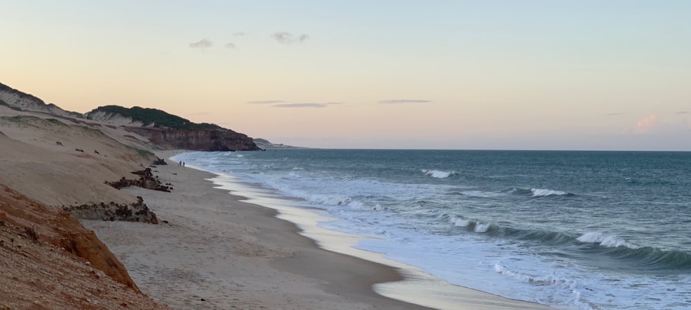 sea waves crashing on shore during daytime