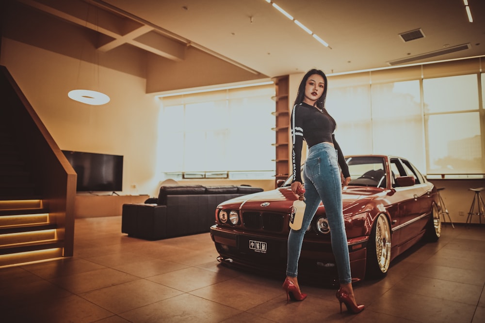 woman in black long sleeve shirt standing beside red and black sports car