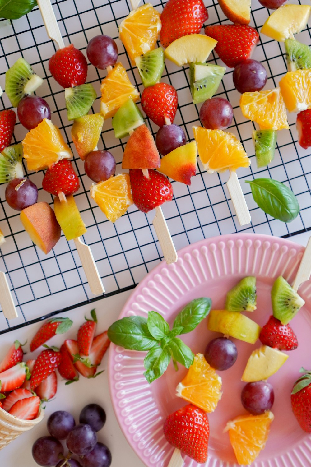 sliced strawberries and bananas on pink plastic plate