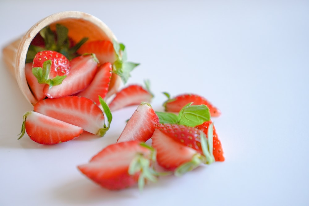 sliced strawberries on white ceramic bowl
