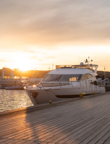 white and black yacht on dock during sunset