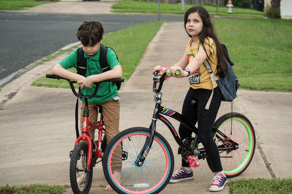 woman in green shirt riding red bicycle beside woman in green shirt during daytime