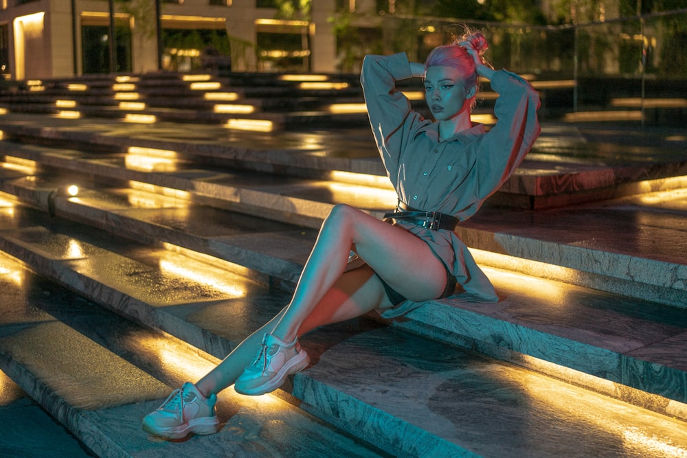 woman in blue long sleeve shirt sitting on blue and white pool during daytime