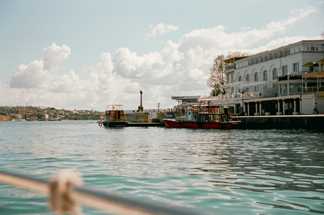 white and brown ship on sea under white clouds and blue sky during daytime