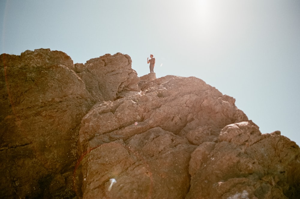 person standing on brown rock formation during daytime