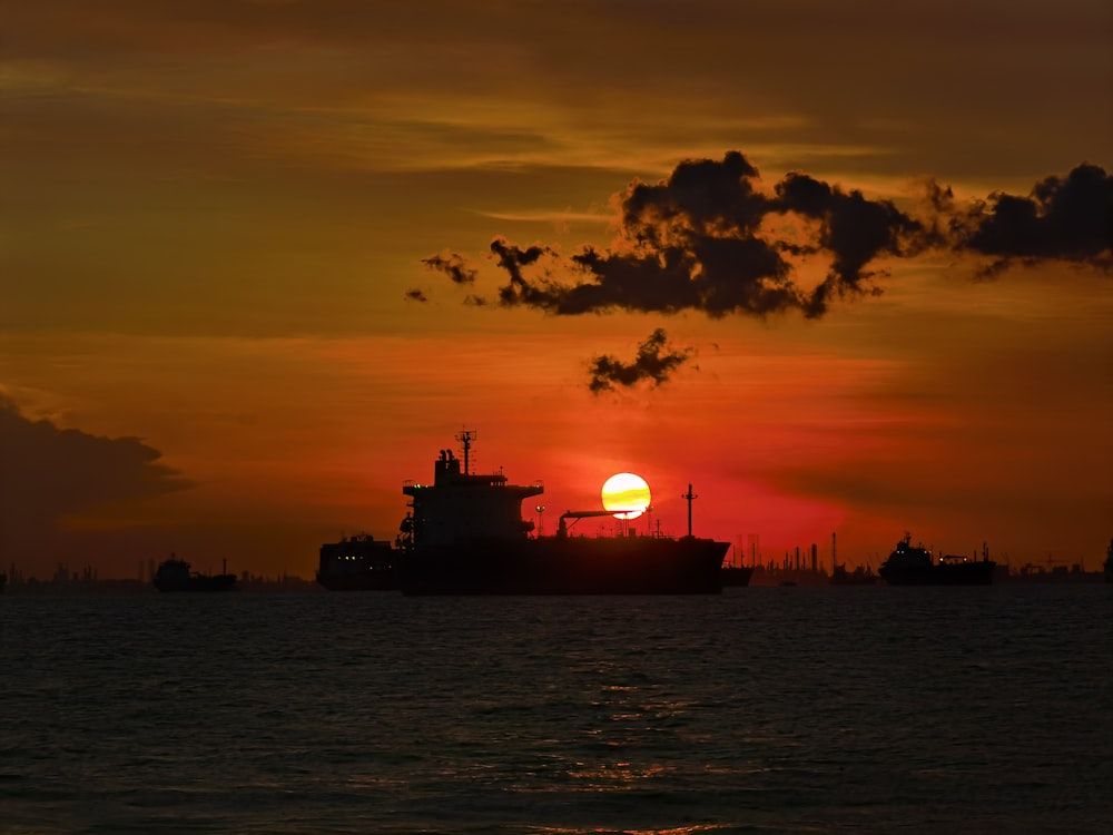 silhouette of ship on sea during sunset