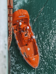 orange and white boat on water during daytime