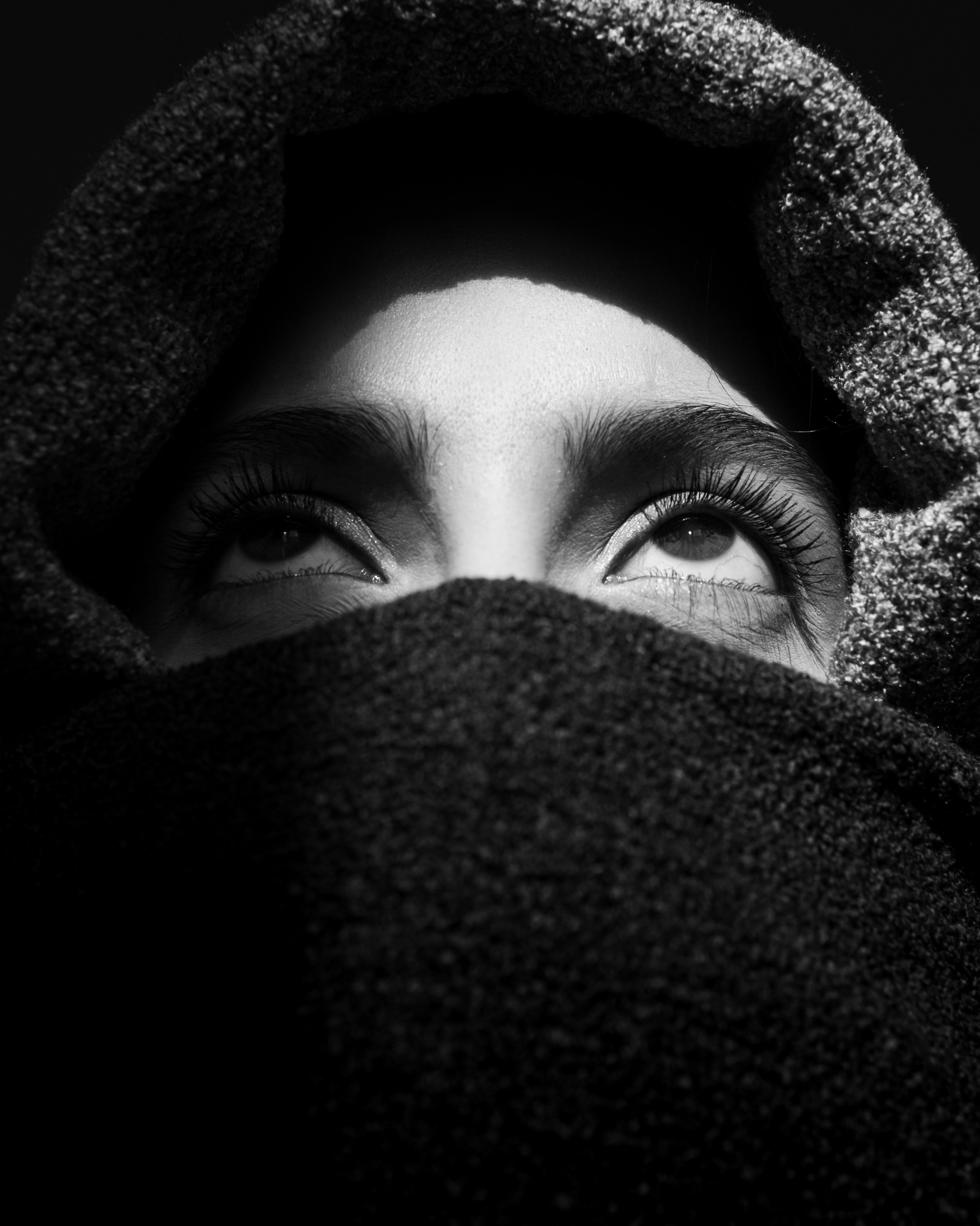 grayscale photo of woman covering her face with blanket