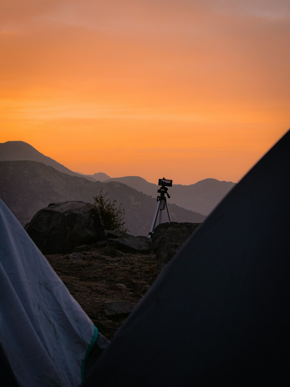 silhouette of man standing on rock formation during sunset