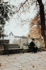 An elderly man reflecting thoughtfully while sitting on a park bench.
