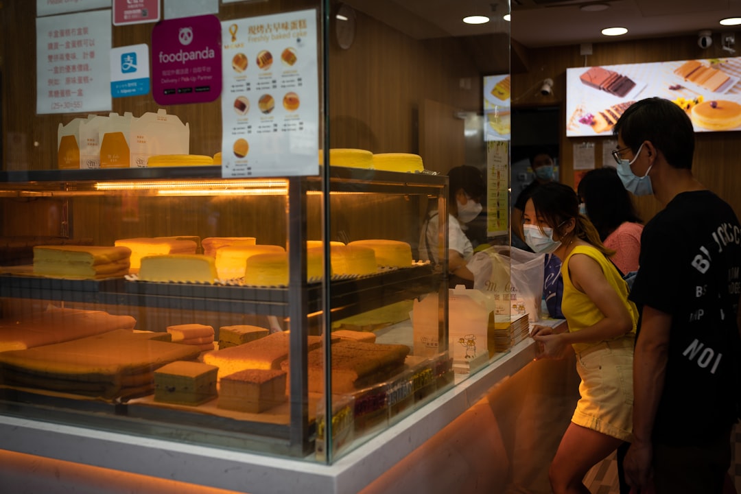 woman in yellow shirt standing in front of food counter