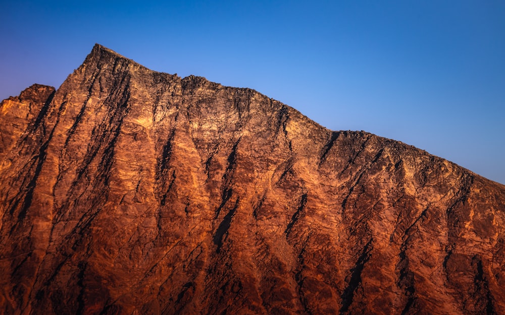 brown rocky mountain under blue sky during daytime