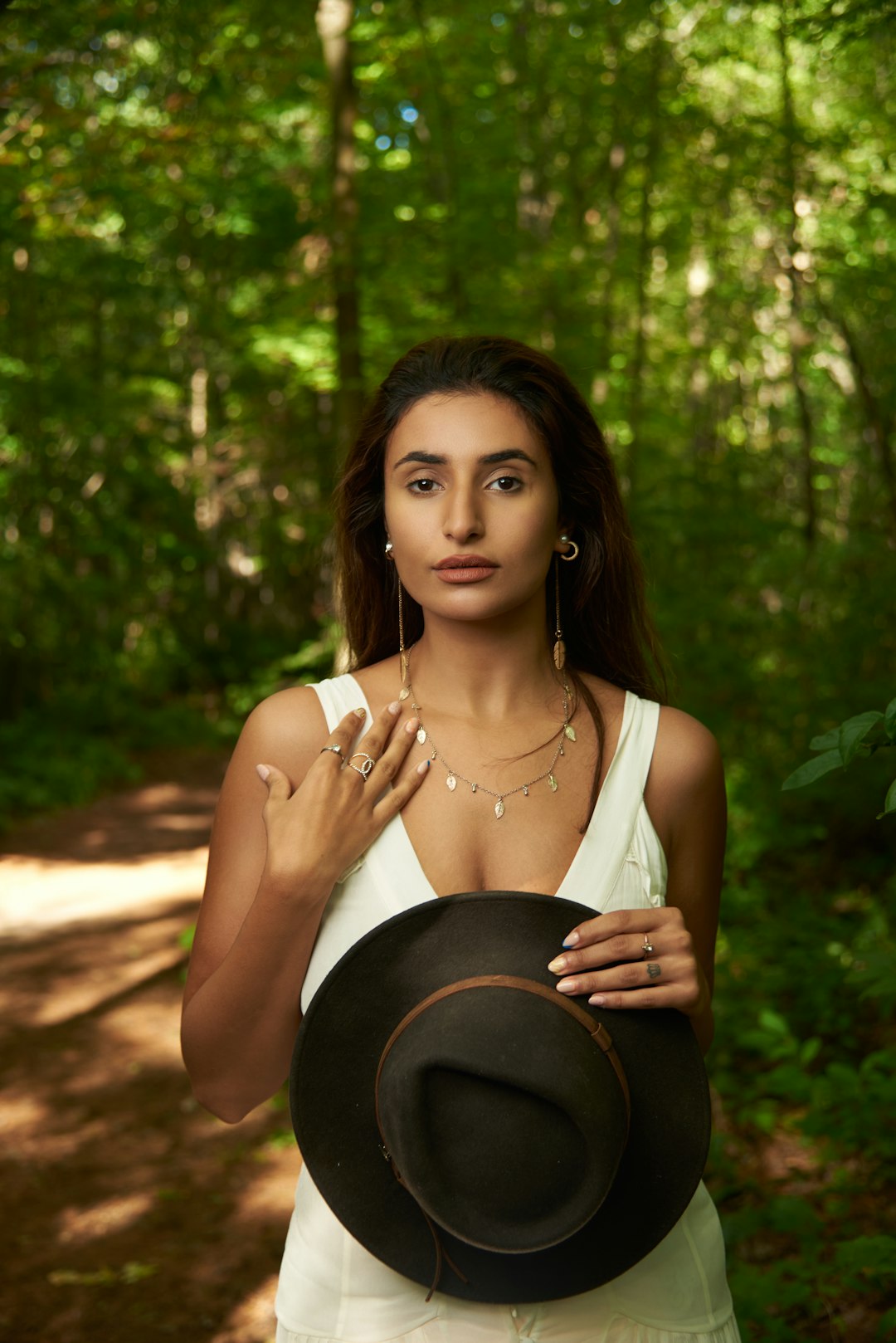 woman in white tank top holding her head