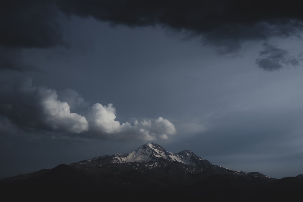 Weiße Wolken über schneebedecktem Berg